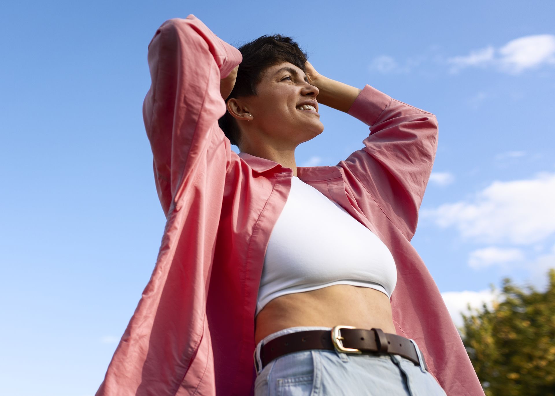 Mulher ao ar livre, de camisa aberta, olhando para o horizonte